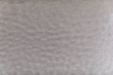 Close-up on a glass pane with unstructured patterns due to the roughness present in the material. it...