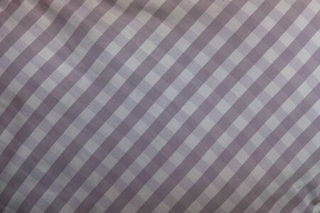 Close-up on the fabric of a pillow. it is made up of a repetitive geometric pattern of small tiles...