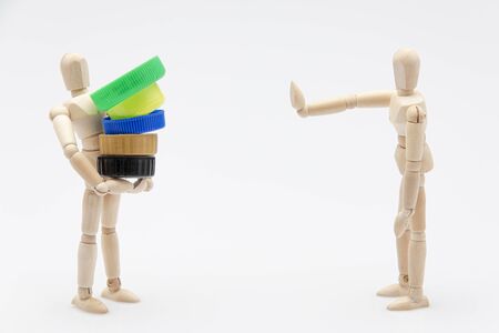 Wooden dummy refusing plastic plugs in front of a white background