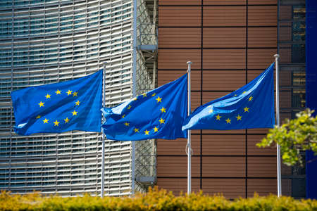 BRUSSELS, Belgium - fourth of may 2020: flags waving in the wind in front of the Berlaymont building, the headquarters of the European Commission.のeditorial素材