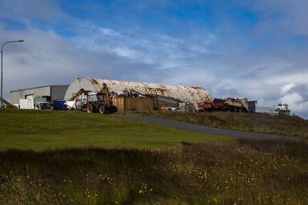 landscape with the port of the island of grimsey in the north of iceland, off the arctic circle. an old barn is on the edge of the cliff with some green vegetation around Langue des mの写真素材