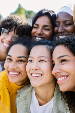 Happy group of diverse women friends hugging each other posing for photo outdoorの写真素材