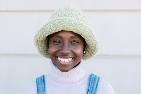 Trendy young african american woman smiling at camera outdoors