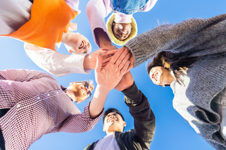 Young people joining their palms in a circle and showing unity and support