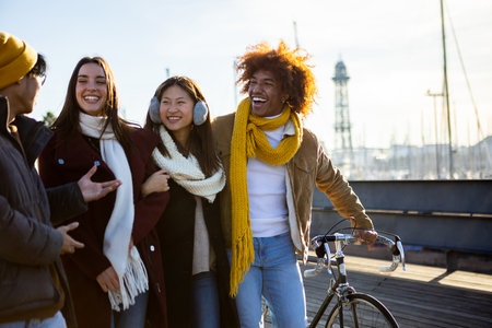 Group of multi-ethnic happy friends walking on street and talking together.