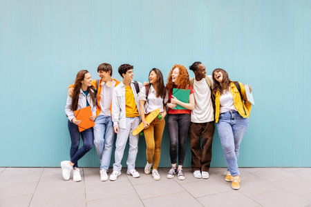 Happy multiracial students standing over isolated blue background