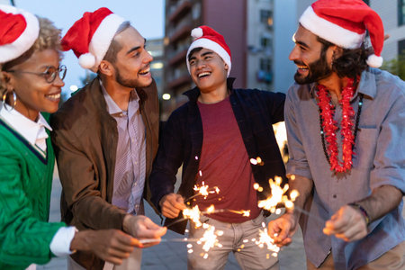 Happy young friends wearing Santa Claus hat celebrating together at Christmasの写真素材