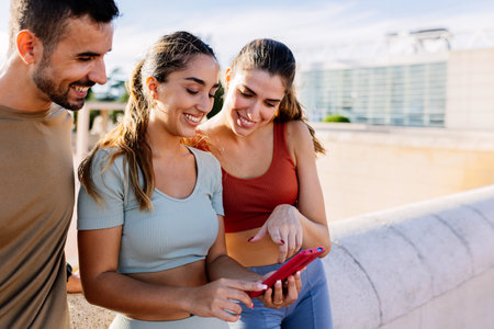 Young group of healthy people using mobile phone together outdoor.