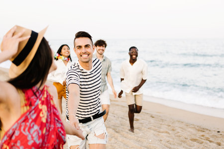Group of young friends running on the beachの写真素材