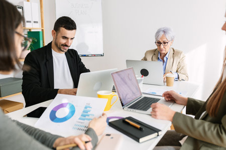 Teamwork analyzing data and graphics during a meetingの写真素材