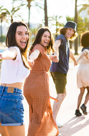 Multiethnic group of young friends running happily together