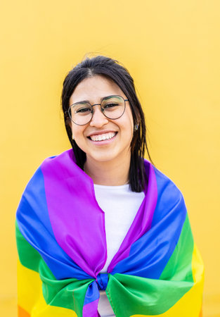 Portrait of young lesbian woman smiling at camera over yellow backgroundの写真素材
