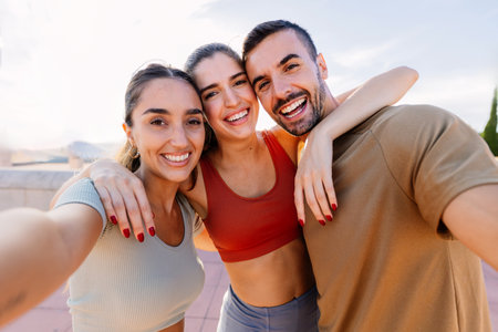 Three young sportive friends taking selfie after workout routine outdoorの写真素材