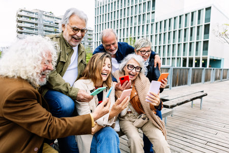 Senior group of people using mobile phone together sitting outdoor