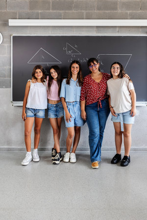 Portrait of elementary student friends with female teacher smiling at cameraの写真素材
