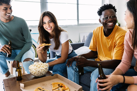 Happy diverse friends having fun together eating pizza at homeの写真素材