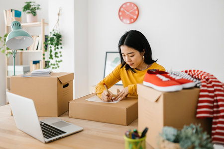 Small business asian owner preparing packages for deliver to customer.