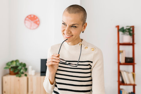 Thoughtful portrait of mid adult entrepreneur woman standing in the office.の写真素材