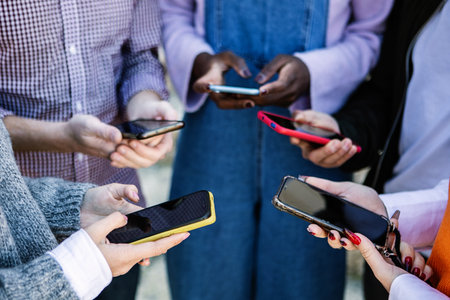 Close up young people hands using mobile phone togetherの写真素材