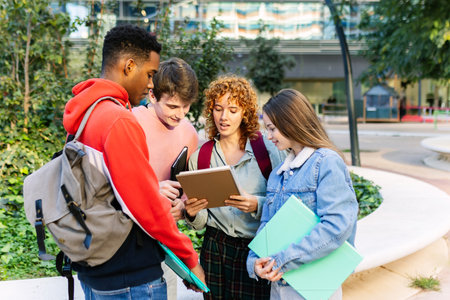 Group of students reviewing notes before an exam near university buildingの写真素材