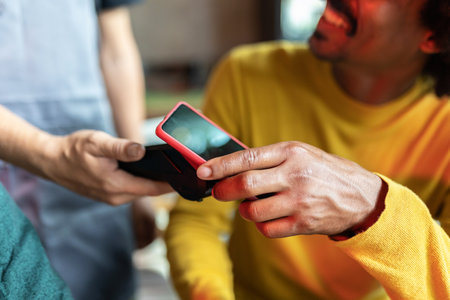 Friends paying for drinks with contactless technology in bar