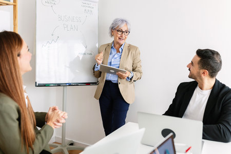 Senior businesswoman leading a presentation with her team in the office