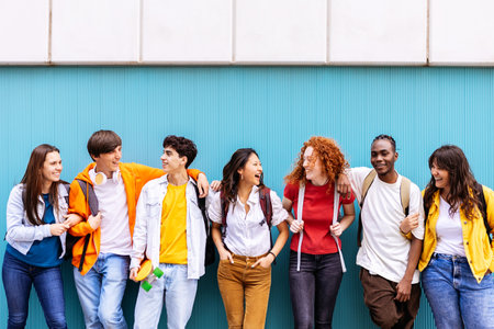Happy multiracial students standing over isolated blue background