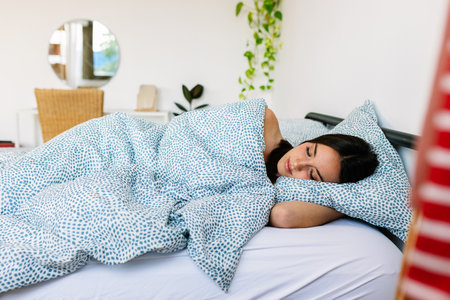 Young woman sleeping in bed in the morning at home