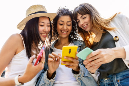 Happy group of young women using smartphones outdoorの写真素材