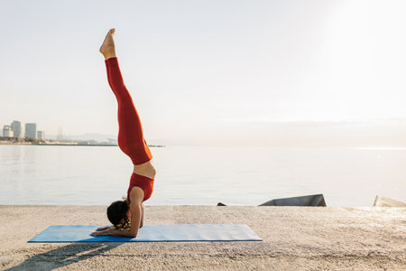 Young adult woman practicing yoga outdoors