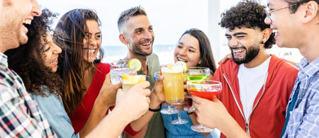 Young multiethnic friends having fun while drinking cocktails at terraceの写真素材