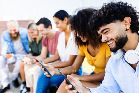 Group of young people using mobile phone in city street
