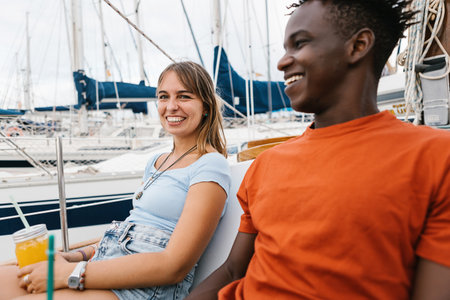 Happy multiracial couple having fun outdoors on a boat.の写真素材