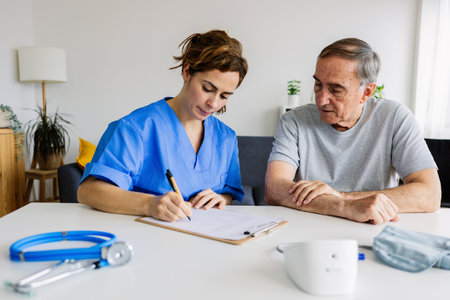 Female doctor visiting elderly man at homeの写真素材