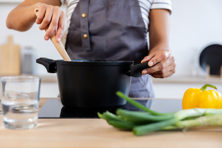 Chef cooking soup in modern kitchen with fresh ingredientsの写真素材