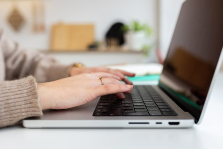 Female student hands typing on laptop keyboard, learning online at home