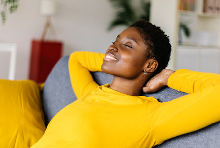 Young african american woman relaxing on sofa at home