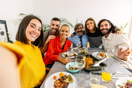 Group of multi-generational family enjoying dinner party taking selfie together