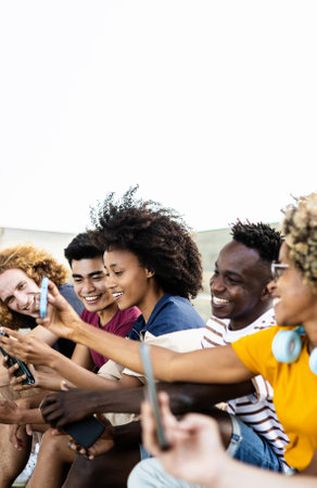Young group of multiracial people using smartphone outdoorsの写真素材