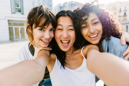 Three female friends enjoying summer vacation taking selfie portrait outdoors