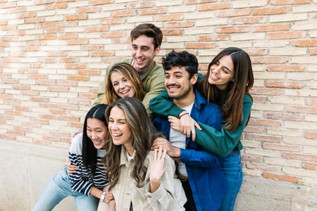 Happy young multiracial friends embracing and smiling at city streetの写真素材