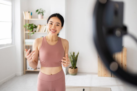 Fitness asian young woman recording online class at homeの写真素材
