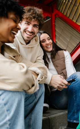 Vertical shot of young happy diverse friends hanging out outsideの写真素材