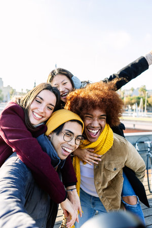 Happy diverse group of friends having fun together on winter season