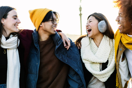 Young diverse gen z friends having fun together at city street on winter