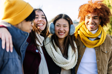 Young diverse gen z friends having fun together at city street on winterの写真素材