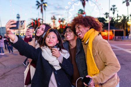 Young happy diverse group in winter clothes taking selfie portrait outdoorsの写真素材