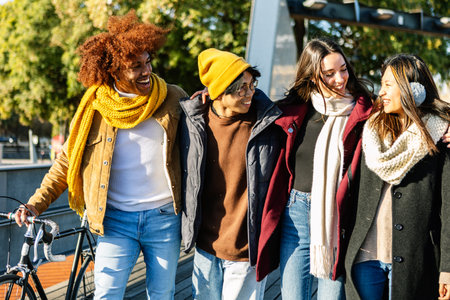 Happy multi-ethnic friends walking together on sunny winter day