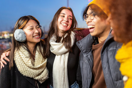 Multiracial group of young people having fun on winter standing outdoorsの写真素材