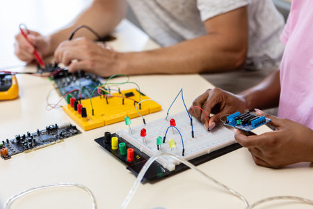 Students working with electronic circuit boards and microcontrollers in science classroomの写真素材
